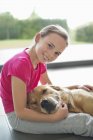 Girl relaxing with dog on floor at modern home — Stock Photo