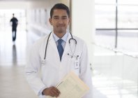 Doctor smiling in modern hospital hallway — Stock Photo