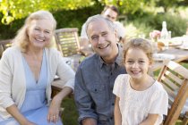 Older couple and granddaughter smiling outdoors — Stock Photo