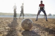 Африканські хлопчики грають у футбол разом у ґрунтовому полі — стокове фото