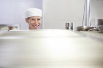 Шеф-повар улыбается на кухне ресторана — стоковое фото