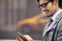 Empresário usando tablet computador na rua da cidade — Fotografia de Stock