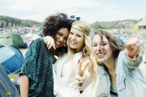 Freunde umarmen sich vor Zelten bei Musikfestival — Stockfoto
