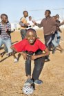 Afrikanische Jungen spielen gemeinsam Fußball auf dem Feld — Stockfoto