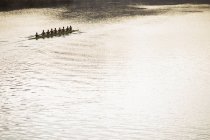 Rowing team in scull on sunny lake — Stock Photo
