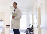 Doctor standing in modern hospital hallway — Stock Photo