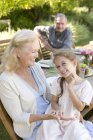 Older woman sitting with granddaughter outdoors — Stock Photo