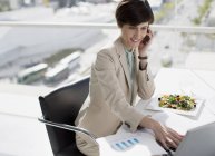 Businesswoman multitasking at desk — Stock Photo