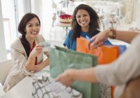 Frau zeigt Freunden Einkaufstüten — Stockfoto