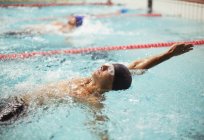 Schwimmer rast im Rückenschwimmen in Becken — Stockfoto