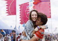 Энтузиастичная пара, обнимающаяся на музыкальном фестивале — стоковое фото