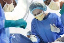 Cirurgiões que trabalham na sala de cirurgia — Fotografia de Stock