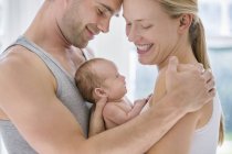 Батьки плескають новонароджену дитину — стокове фото