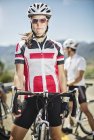 Cyclist standing by bicycle before race — Stock Photo