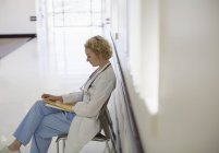 Médico revisando la historia clínica en el pasillo del hospital - foto de stock