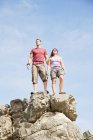Couple d'alpinistes caucasiens sur le sommet d'une colline rocheuse — Photo de stock