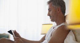 Людина використовує цифровий планшет у ліжку — стокове фото