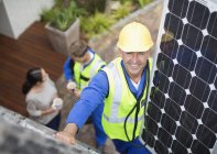 Працівник встановлює сонячну панель на дах — стокове фото