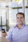 Бизнесмен, использующий мобильный телефон в современном офисе — стоковое фото