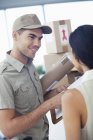 Delivery boy with packages for businesswoman at modern office — Stock Photo