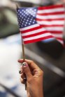 Mulher com unhas novidade acenando bandeira americana — Fotografia de Stock