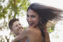 Close up of man spinning smiling girlfriend — Stock Photo