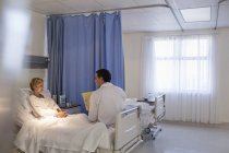 Лікар розмовляє з пацієнтом у лікарняній кімнаті — стокове фото
