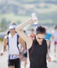 Runner pouring water on head in race — Stock Photo