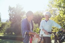 Senior caucasian couple with bicycles in park — Stock Photo