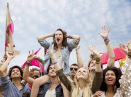 Cheering woman on man shoulders at music festival — Stock Photo