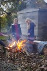 Blonde girls building bonfire outdoors — Stock Photo