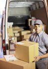 Delivery boy loading boxes into van — Stock Photo