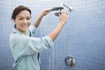 Женщина-сантехник работает над душевой головой в ванной комнате — стоковое фото