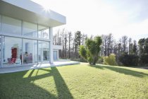 Современный дом отбрасывает тени на ухоженный газон — стоковое фото