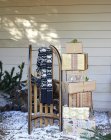 Schal, Holzschlitten und Weihnachtsgeschenke auf verschneiter Veranda — Stockfoto