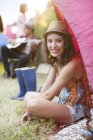 Портрет усміхненої жінки, що сидить у наметі на музичному фестивалі — стокове фото