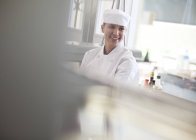 Chef sorridente nella cucina del ristorante — Foto stock