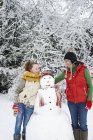 Біла щаслива мати і дочка зі сніговиком — стокове фото