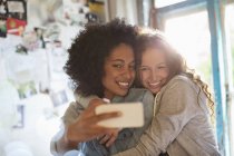 Women taking picture together in bedroom — Stock Photo