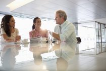 Business people talking in lobby at modern office — Stock Photo