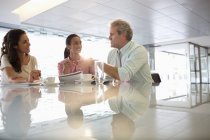 Gente de negocios hablando en el vestíbulo de la oficina moderna - foto de stock