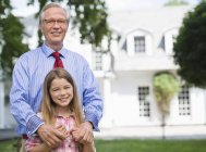 Mann und Enkelin lächeln draußen — Stockfoto