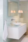 Fregadero, espejo y lámparas en baño moderno - foto de stock