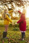 Girls making heart shape with arms outdoors — Stock Photo