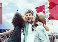Женщины целуют мужчин в щеки на музыкальном фестивале — стоковое фото