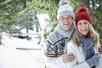 Glückliches kaukasisches Paar, das sich im Schnee umarmt — Stockfoto