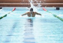Nuotatore che corre in piscina acqua — Foto stock