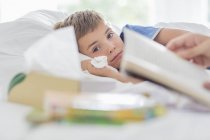 Sick boy laying in bed — Stock Photo