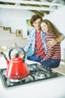 Молода щаслива пара обіймається на кухні — стокове фото