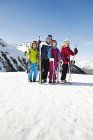 Familia sosteniendo esquís en la cima de la montaña juntos - foto de stock